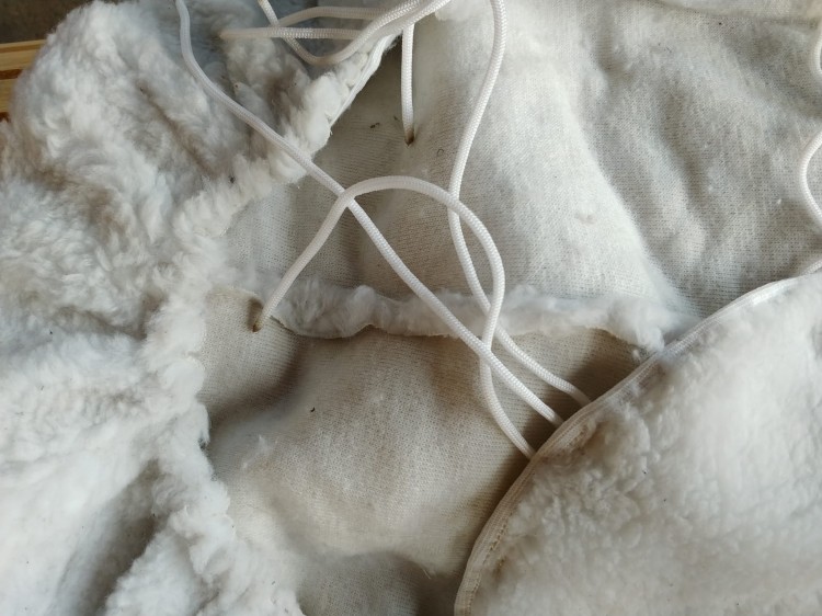 Nakładka futerkowa na siedzisko siodła western — biały miś, widok od spodu, sznureczki i tkanina bawełniana