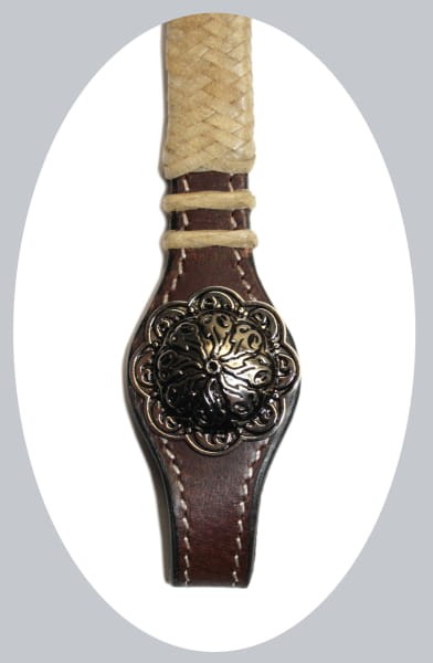 Zbliżenie conchos ogłowia western — kwiatowa concha antyczne wykończenie na ciemnej skórze z plecioną rawhide — HorsePassion.pl