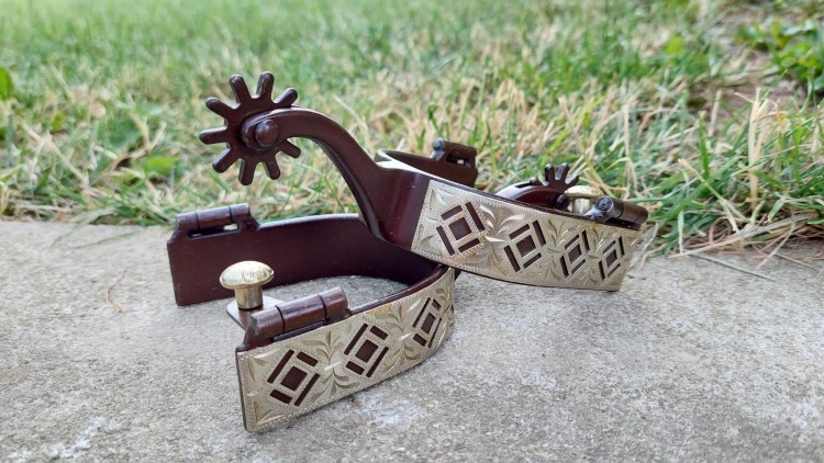 Para ostróg western AHE na betonie  widok nakładki rombowej i złotego guzika