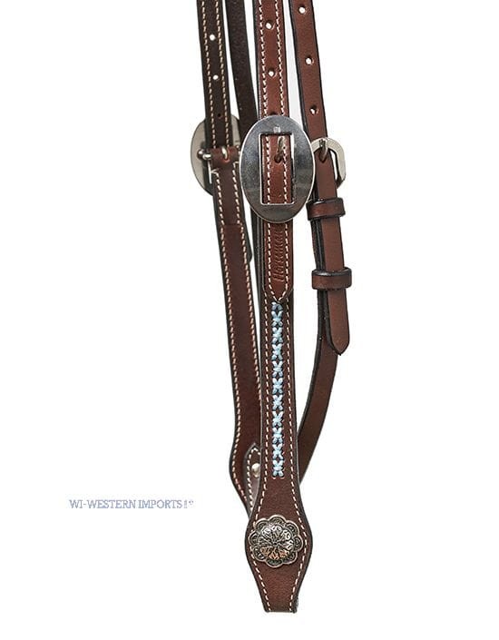 Zbliżenie policzka ogłowia Horseman's Tack — owalna srebrna concha przy klamrze, niebieski haft cross na ciemnej espresso skórze, kwiatowa concha Spanish-cut — HorsePassion.pl