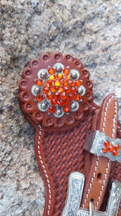 Detal: ogromna rozeta z pomarańczowymi kryształkami — paski do ostróg western show