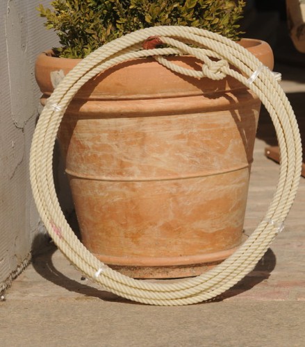 Lasso Supreme Ranch Rope — zwinięte, oparte o donicę ceramiczną, biały woskowany syntetyk z hondą