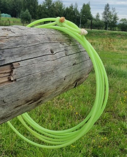 Lasso Classic Equine SPYDR neonowy zielony — zawieszone na belce, widoczna honda i skręt 5-splotowy, tło pastwisko