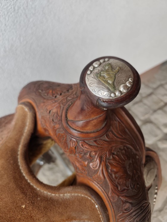 Srebrna kapka hornu z reliefem jeźdźca reiningowego — siodło Marisita Saddlery Robert Baggett