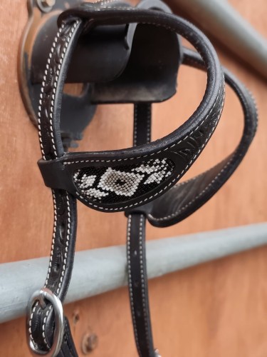 Zbliżenie wstawki beadwork ogłowia western two ear GVR — geometryczny wzór rombów z białych i szarych koralików na czarnej skórze, flower tooling przy pętlach usznych — HorsePassion.pl