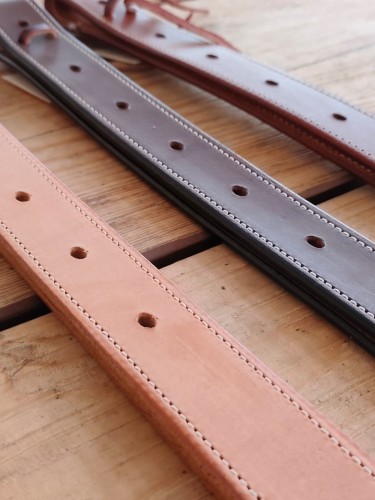 Off billet AK Saddlery detal — naturalna skóra pełnoziarnista, białe kontrastowe przeszycie, otwory regulacyjne