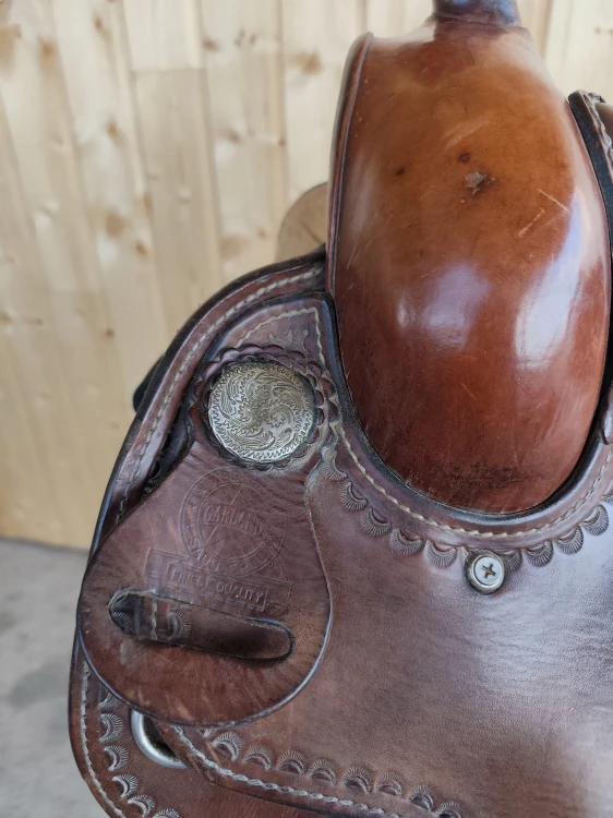 Stempel Garland Saddlery Finest Quality — antyczna concha na połce siodła western